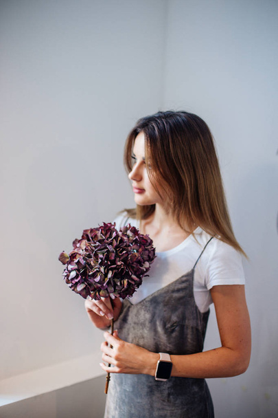 Girl with a branch of dry hydrangea. - Photo, image