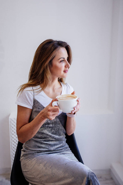 Cup of cappuccino in hand beautiful girl. - Valokuva, kuva