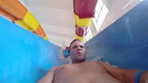 Чоловік спускається з водної гірки до басейну в аквапарку. всередині труби. 4k
 - Кадри, відео