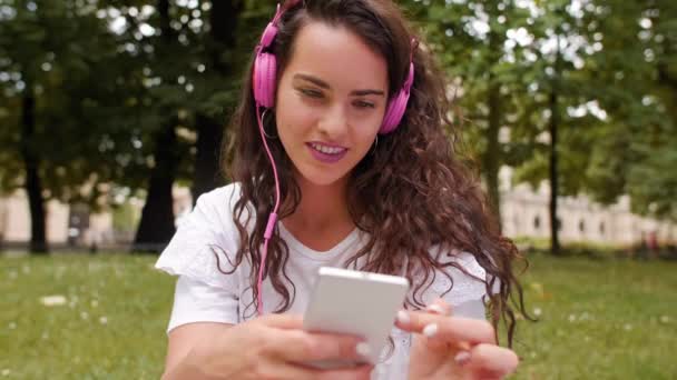 Tyttö käyttää matkapuhelinta puistossa
 - Materiaali, video