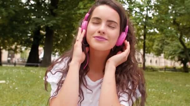 Mladá žena poslechu hudby pomocí sluchátek - Záběry, video