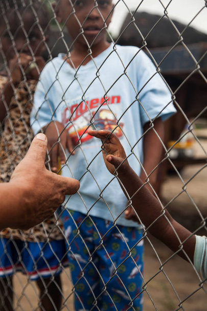 мужчина протянет руку ребенку, необходимому в Африке
. - Фото, изображение
