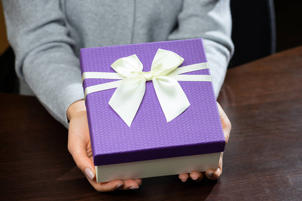 Purple little gift box with ribbon in woman hands. For Mothers D - Foto, immagini