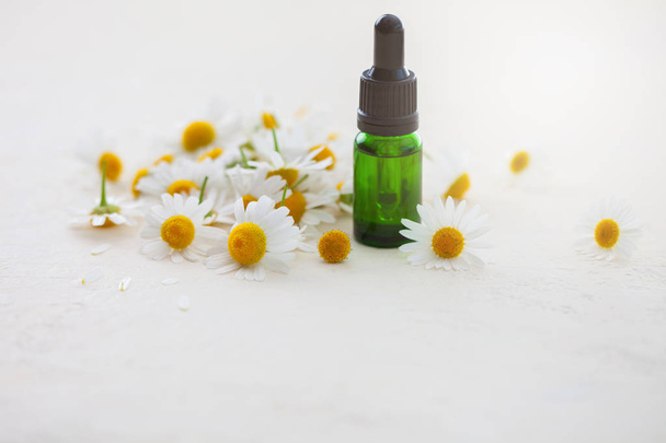 aceite esencial de aromaterapia con flores de manzanilla aisladas sobre fondo blanco
 - Foto, imagen