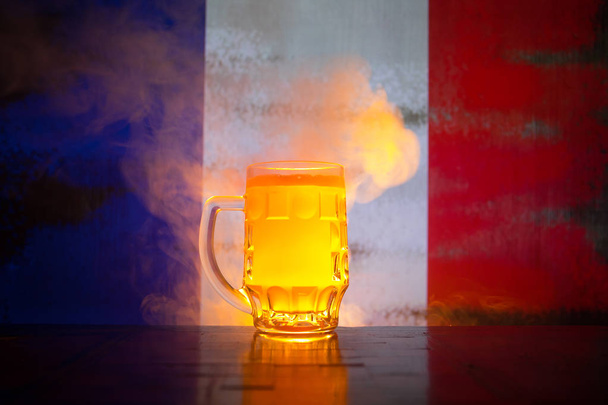 Yaratıcı kavramı. Taze bira masada bir bardak bulanık arka plan üzerinde Fransa bayrağı veya lager bira içmeye hazır kadeh. Uzay kopyalayın. Seçici odak - Fotoğraf, Görsel