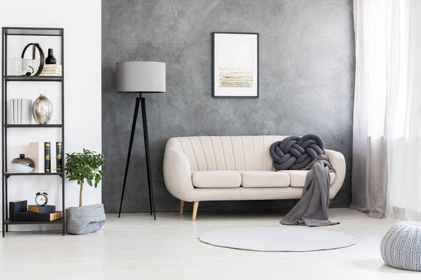 Poster mock-up on a gray, concrete wall and a leather beige settee in an industrial living room interior with black, wooden furniture - Фото, изображение