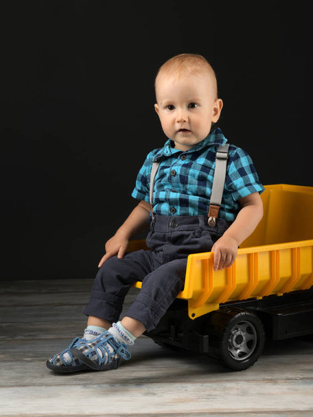 niño juega con camión de juguete grande - Foto, Imagen