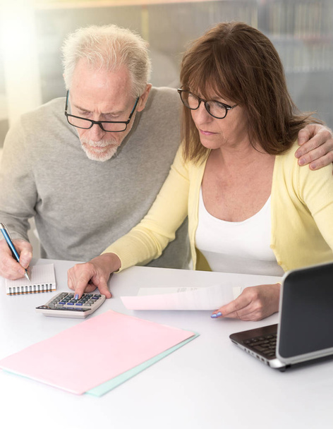 Senior coppia controllo documento finanziario a casa, effetto luce
 - Foto, immagini
