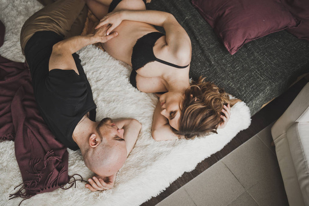 Newlyweds look at each other lying in bed. - 写真・画像