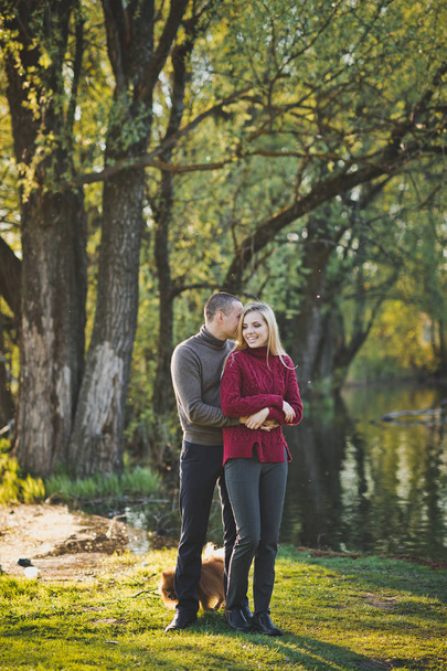 Guy and girl hugging standing on the shore of the pond. - Photo, image