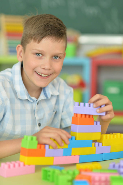  Menino brincando com blocos de plástico coloridos
 - Foto, Imagem
