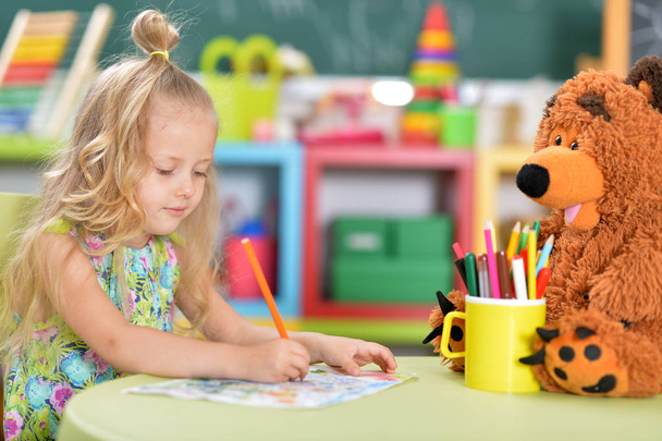  cute little girl drawing at table - Photo, image