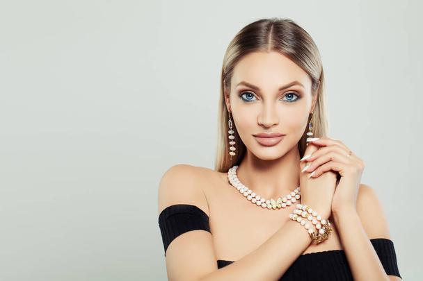 Perfect Young Woman with Makeup, Jewelry Necklace and Earrings on Gray Background - Fotó, kép