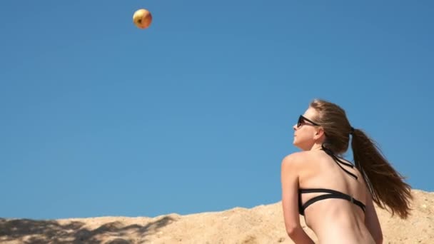 Slow motion: Sexy mladá dívka v černých plavkách a brýle, ničí ovoce a zeleniny s baseballovou pálkou. Nachází se na písečné pláži v blízkosti moře v létě. Přeruší apple. - Záběry, video