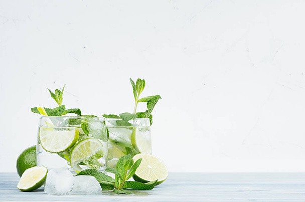 Cold detox summer mineral water with lime, mint, ice, straw on soft white background, copy space. - Fotografie, Obrázek