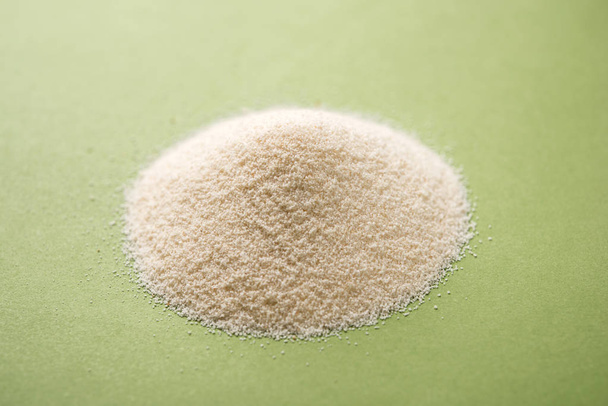Hrubý, čištěný Pšenice krupičných pšenice je syrové semolinové mouky nebo prášku Rava. Podává se po jednoduché pozadí, jako haldu nebo v misce nebo lžící. Selektivní fokus - Fotografie, Obrázek