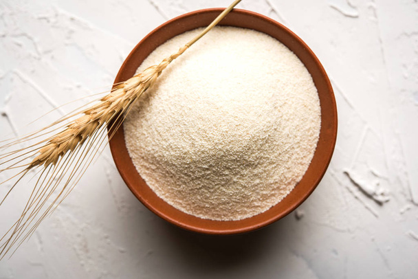 Hrubý, čištěný Pšenice krupičných pšenice je syrové semolinové mouky nebo prášku Rava. Podává se po jednoduché pozadí, jako haldu nebo v misce nebo lžící. Selektivní fokus - Fotografie, Obrázek