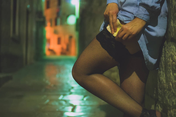 Una prostituta che lavora sulla strada di notte. Nascondere i soldi
. - Foto, immagini