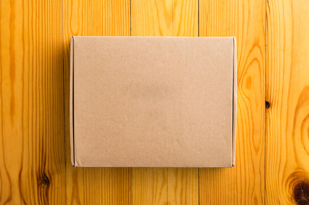 Craft unlabeled cardboard box with copyspace for text on wooden  - Foto, immagini