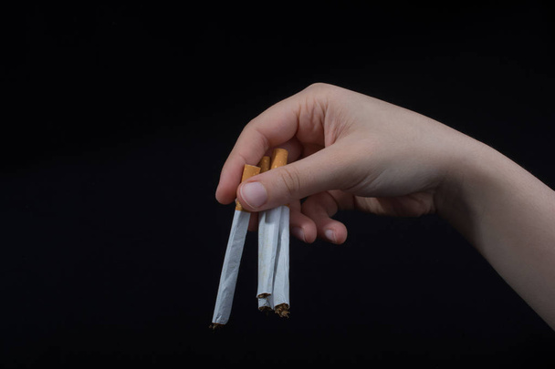 Hand houdt sigaretten op zwarte achtergrond - Foto, afbeelding