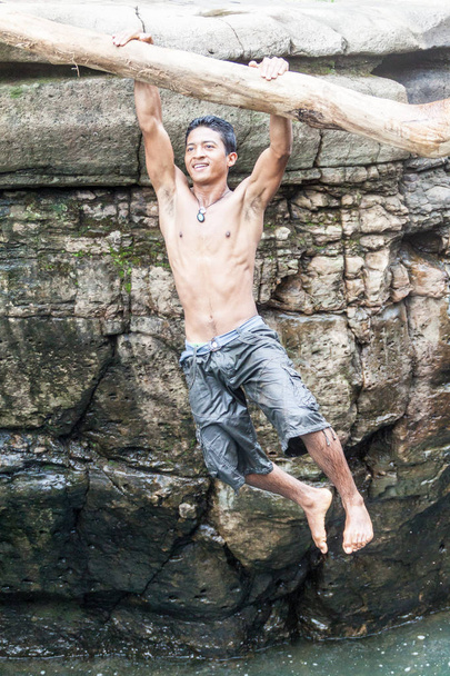 GUALACA, PANAMA - MAY 23, 2016: Local male jumps in a water in Los Cangilones de Gualaca - mini canyon in Panama - 写真・画像