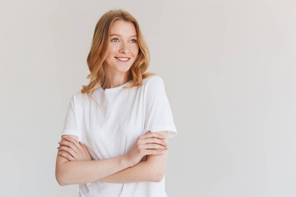 Image of amazing young cute redhead woman standing isolated over white wall background looking aside. - Foto, afbeelding