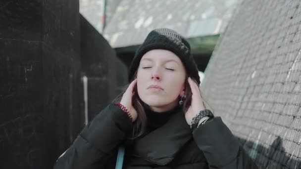 portrait of a woman tourist puts on black cap, walks on Europe - 映像、動画