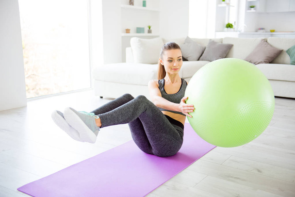 Beauty power legs sport clothing hobby day dream sofa domestic healthy lifestyle concept. Close up view photo of beautiful attractive pretty cheerful satisfied lady using ball for doing exercises - Zdjęcie, obraz