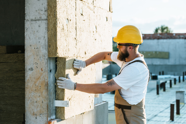 Builder koruyucu kask ve izolasyon inşaat sahasında duvar yapıyor googles '  - Fotoğraf, Görsel