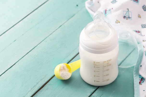 Baby bottle and milk on blue wooden table. Copyspace - Photo, Image