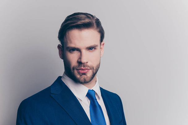 Portrait of cool, brutal, stunning, brunet, serious, concentrated man with stubble in blue suit with tie, looking at camera, isolated on grey background - Foto, immagini