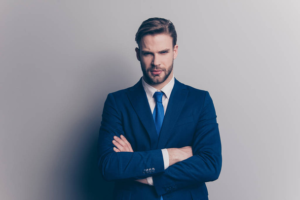 Portrait of cool, brutal, stunning, brunet, serious, concentrated man with stubble in blue suit with tie, having his arms crossed, looking at camera, isolated on grey background - Photo, Image