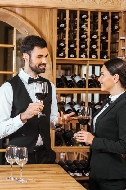 couple of wine stewards making degustation together and chatting at wine store - 写真・画像
