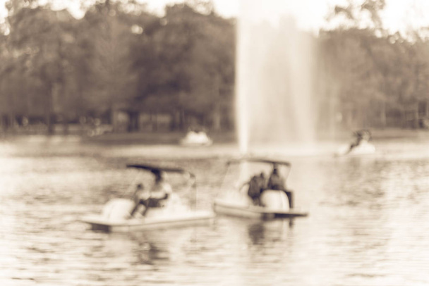 Unscharfe Bewegung Einheimische und Touristen tragen Schwimmwesten beim Tretbootfahren in der Nähe des Brunnens im Hermann Park Conservancy in Houston, Texas, us. Familienmitglied, Freund genießen Outdoor-Aktivitäten. Vintage-Ton - Foto, Bild
