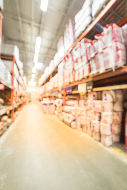 Blurred a large hardware store. Defocused interior of home improvement retailer with aisles, shelves and racks of building material insulation from floor to ceiling. Construction wholesale concept. - Foto, Imagen