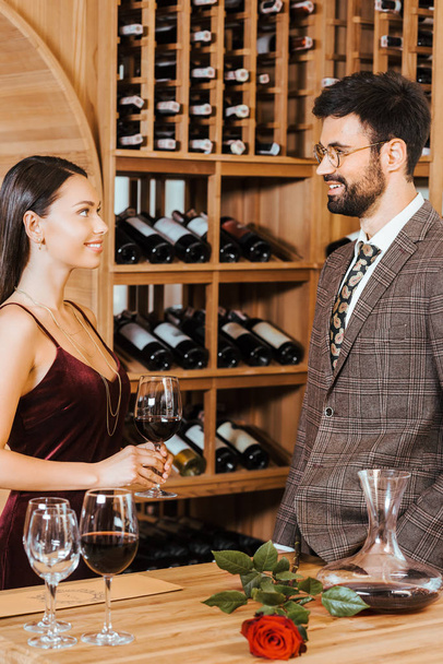 feliz pareja elegante charlando en el almacenamiento de vino
 - Foto, imagen