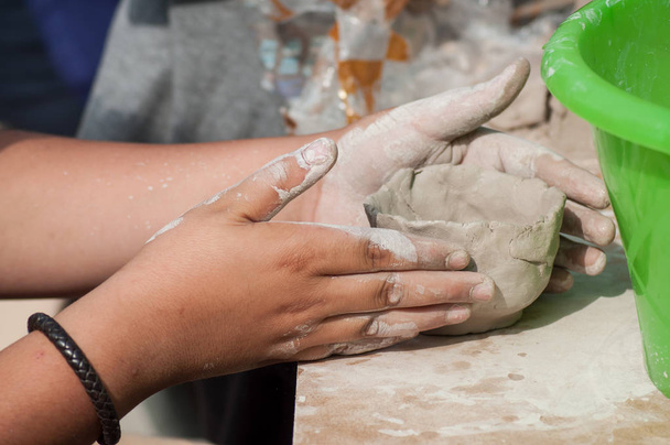 closeup of hands of child making clay pottery bowl  in outdoor  - Фото, изображение