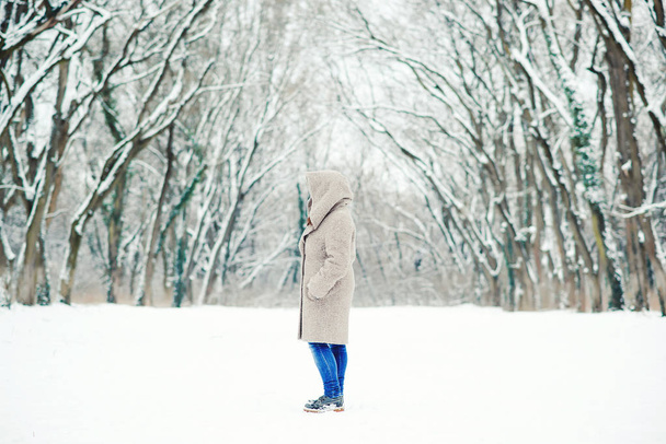 Nő a behavazott téli erdőben. Téli lány séta a téli park szabadtéri. Téli divat fogalmát. Téli ünnepek. Gyönyörű téli táj. Havas téli reggel - Fotó, kép