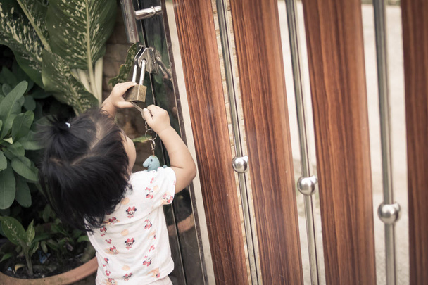 bambina mette la chiave nel buco della serratura
 - Foto, immagini