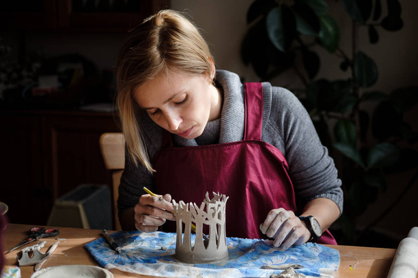 Donna vasaio facendo composizione albero in ceramica sul posto di lavoro ceramica. Modellazione ceramista su laboratorio di ceramica
. - Foto, immagini