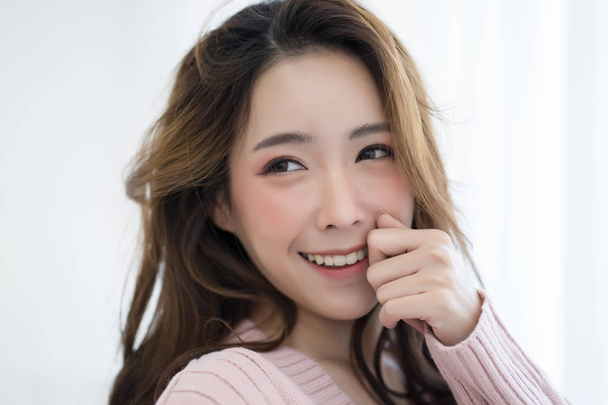 Ritratto ravvicinato di donna asiatica caucasica ispirata che indossa maglione rosa freddo sorridente e scattando selfie. Isolato sfondo bianco
 - Foto, immagini