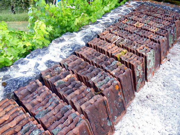 Vieilles tuiles en terre cuite retirées d'un toit d'atelier, couvertes de crasse et de lichen
 - Photo, image