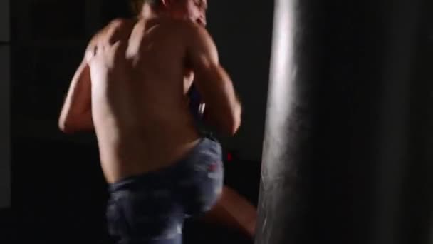 Man boxer making strikes on a boxing bag. Fighter training indoor - Felvétel, videó