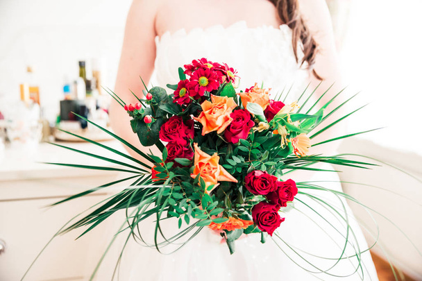 Nieuw wo vrouw houdt haar rood, oranje en groen Bridal Bouquet - Foto, afbeelding