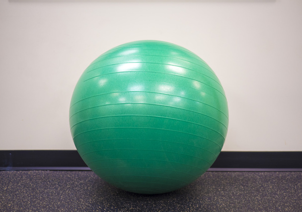 Bola de ejercicio verde solitario aislado en el gimnasio
 - Foto, imagen