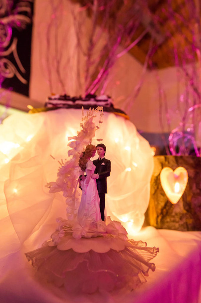 Décoration de gâteau de mariage de mariée et de marié avec la lumière de bougie
 - Photo, image