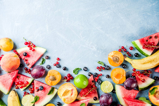 Sommer-Vitamin-Food-Konzept, verschiedene Früchte und Beeren Wassermelone Pfirsich Minze Pflaume Aprikosen Blaubeere Johannisbeere, kreative flache Lage auf hellblauem Hintergrund von oben Ansicht Kopierraum - Foto, Bild