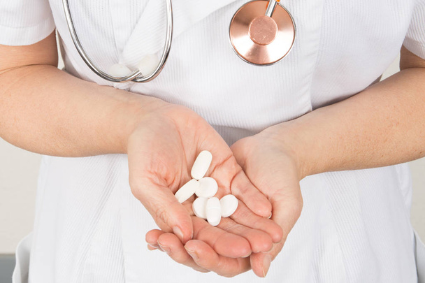 médico femenino con las manos llenas de medicamento en cápsulas de comprimidos
 - Foto, imagen