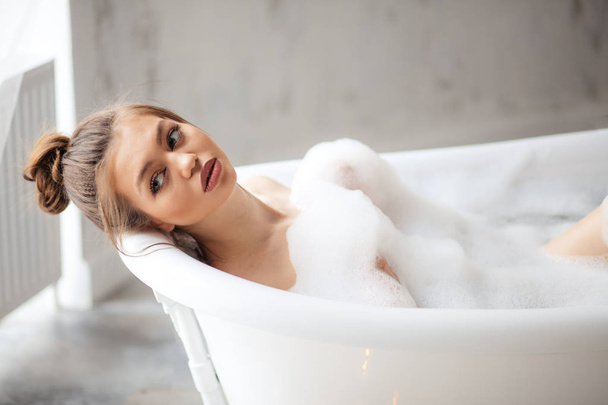 thoughtful attractive model in bath with foam - Photo, Image