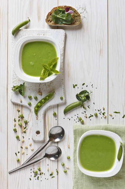Homemade fresh green pea cream soup with spices, pine nuts and toast - Photo, image